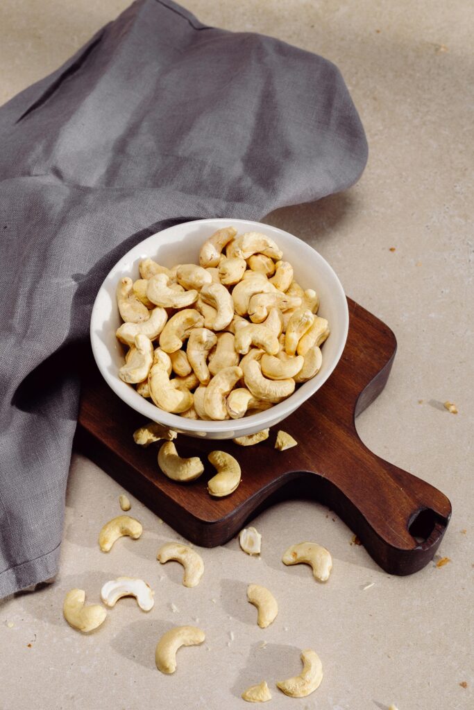 pexels photo 4499222 4499222 Top view of cashew nuts in a bowl on a wooden cutting board, perfect for healthy snack concepts.